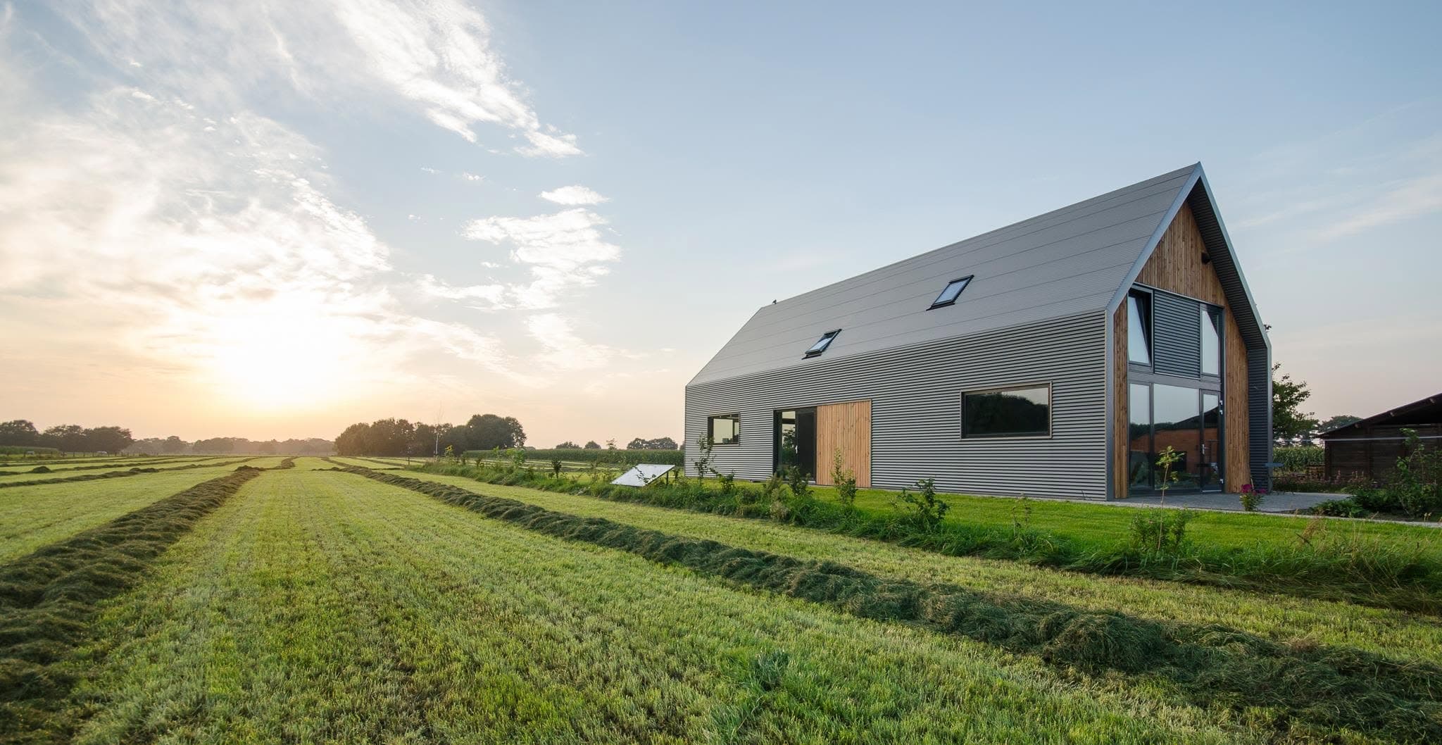 Loftvilla in een weiland bij zonsondergang